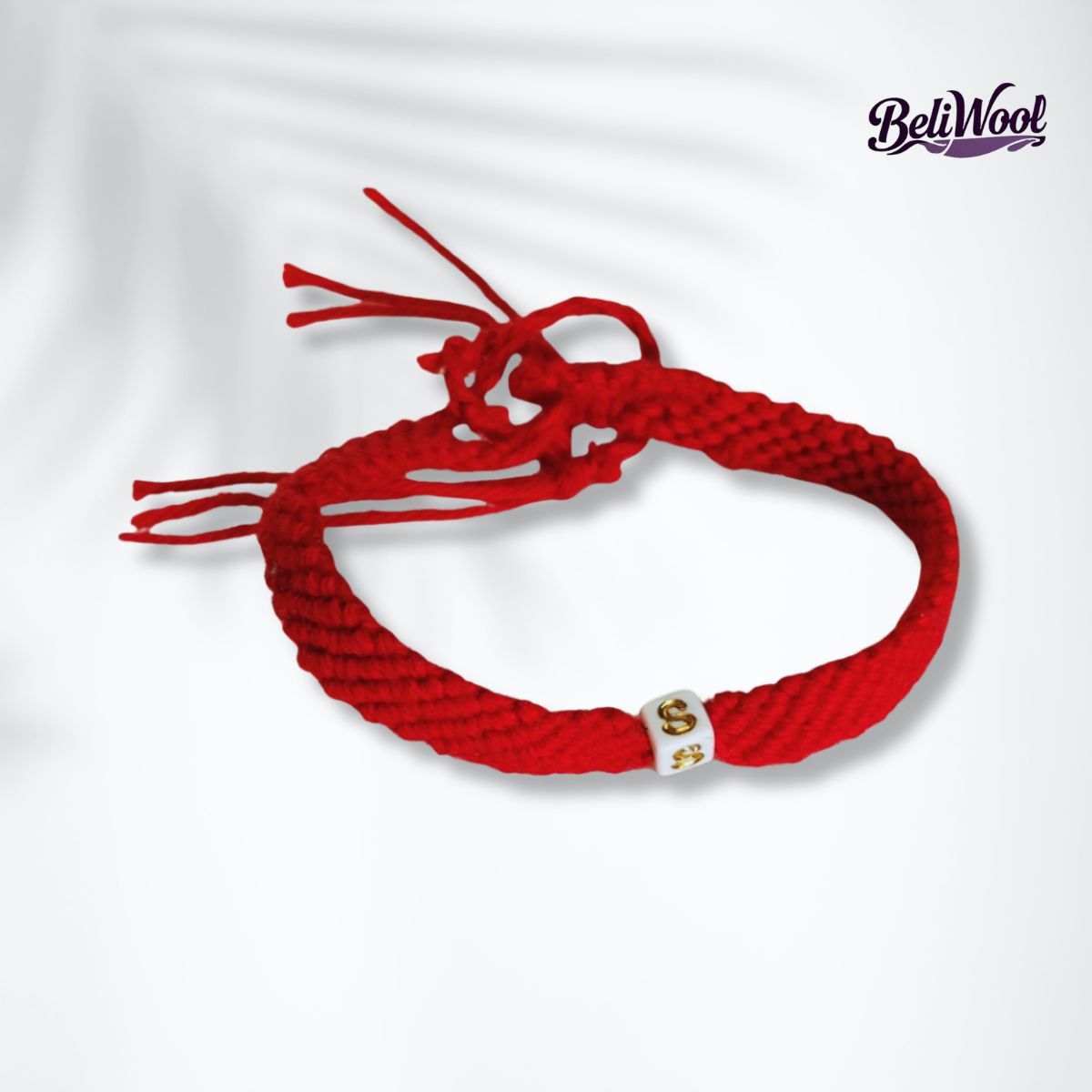 Pulsera Hilo rojo de 25cm Pulsera hilo rojo amarrada puesta en forma circular sobre tela blanca